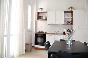 Departamento Confort, balcón | Cocina privada | Refrigerador, microondas, horno y parrilla de estufa 