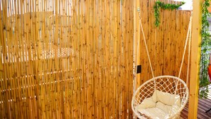 A bamboo fence with a hanging chair. - Case Vacanze Il Sorriso (Catania)