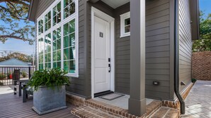 A house with a front porch, a white door, and a large window. - Downtown Cottage Hideaway Suite B (Fairhope)