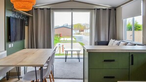 Eine moderne Küche mit Essbereich, großen Fenstern und Blick nach draußen.