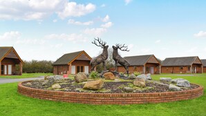 A lodge with two deer statues in a landscaped garden, surrounded by brick walls and a clear sky. - A great location to explore the stunning East Riding of Yorkshire. (Fitling)