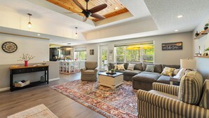 A spacious living room with a ceiling fan, a large rug, and a sofa.