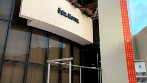 Un hotel moderno con un letrero llamativo que dice 'CSR Hotel' y fachada de vidrio.