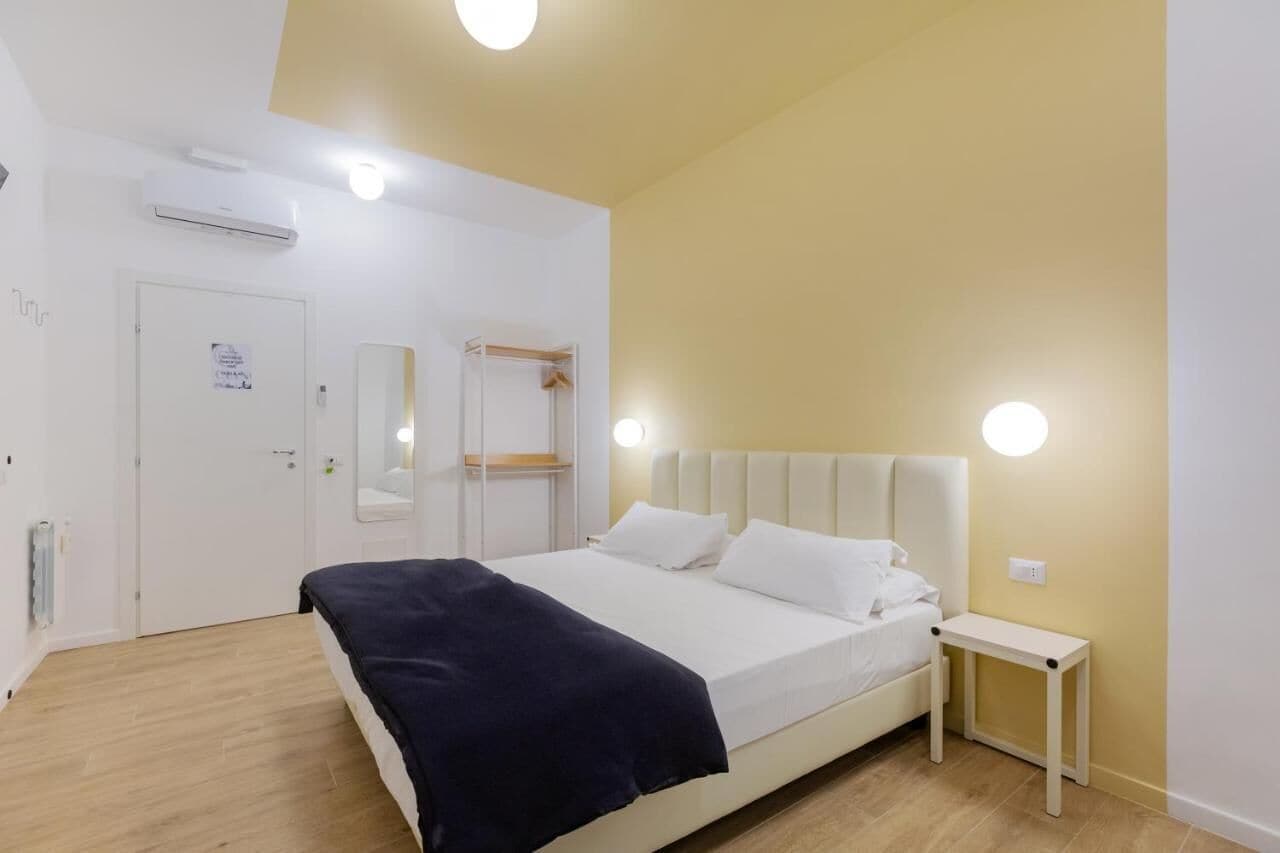 Una camera da letto con un letto, un comodino e uno specchio.