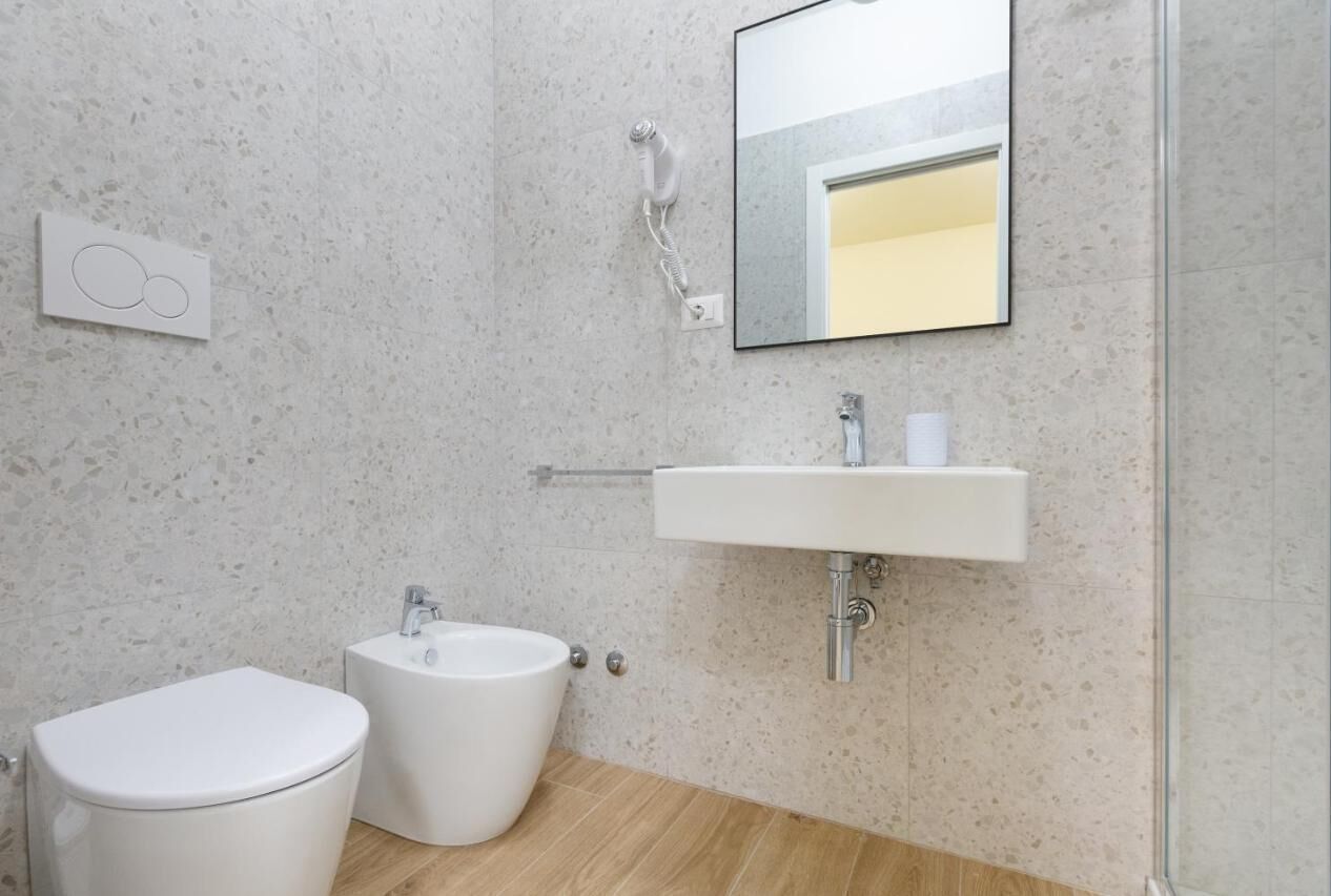 A modern bathroom with a toilet, bidet, and sink.