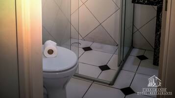 Un baño con cabina de ducha de vidrio, inodoro y lavabo con encimera de mármol.