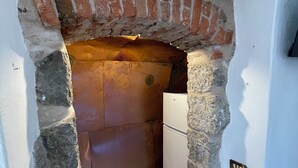 A narrow stone archway leading to a small room with a refrigerator. - House Old town 50m beach'shop (Menton)