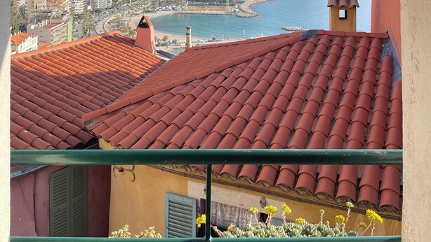 A balcony with a red-tiled roof overlooking a coastal town with a clear view of the sea and mountains. - House Old town 50m beach'shop (Menton)