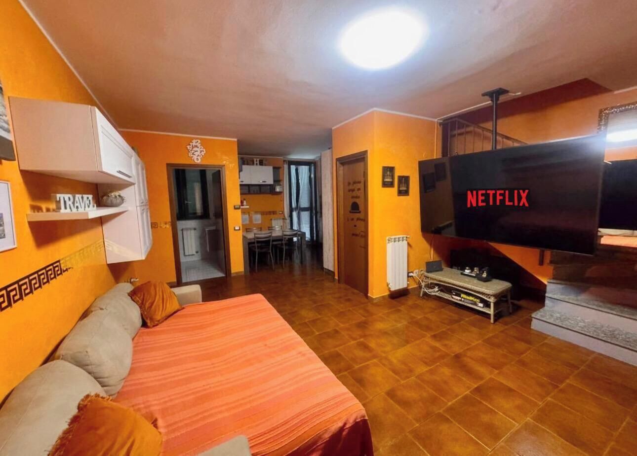 Une chambre comprenant un lit, un téléviseur et un coin cuisine.