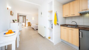 Una cocina moderna con muebles blancos, encimera de granito y lavavajillas empotrado.