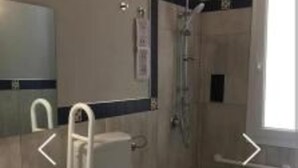 Une salle de bain avec des toilettes, un lavabo et une douche.