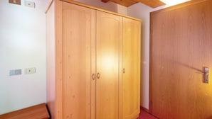 Ein Zimmer mit einem Holzschrank, einer Tür und einem roten Teppich.