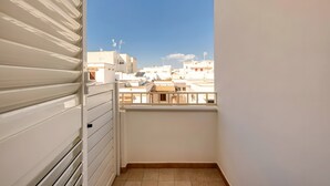 Een balkon met uitzicht op gebouwen en een heldere lucht.