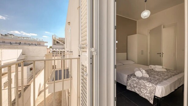 Ein Schlafzimmer mit Bett, Kleiderschrank und Balkon.