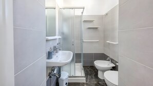 A modern bathroom with a glass-enclosed shower, a sink, a bidet, and a toilet. - Apartment 'Grande Struttura - Matrimoniale 6' with Balcony, Wi-Fi and Air Conditioning (Torre San Giovanni)