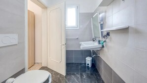 Un baño moderno con inodoro, lavabo y espejo.