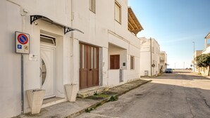 A narrow street with white buildings, a no parking sign, and a clear sky. - Apartment 'Grande Struttura - Matrimoniale 1' with Balcony, Wi-Fi and Air Conditioning (Torre San Giovanni)