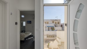 A hotel room with a bed, a bathroom, and a view of the street. - Apartment 'Grande Struttura - Matrimoniale 1' with Balcony, Wi-Fi and Air Conditioning (Torre San Giovanni)