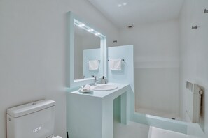 A modern bathroom with a white sink, a large mirror, and a shower area. - Villa 'Afroditi B' with Sea View, Wi-Fi and Air Conditioning (Antiparos Town)