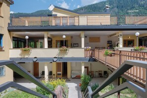 Un hôtel doté d’un balcon au deuxième étage, d’un espace extérieur aménagé et offrant une vue sur la montagne.