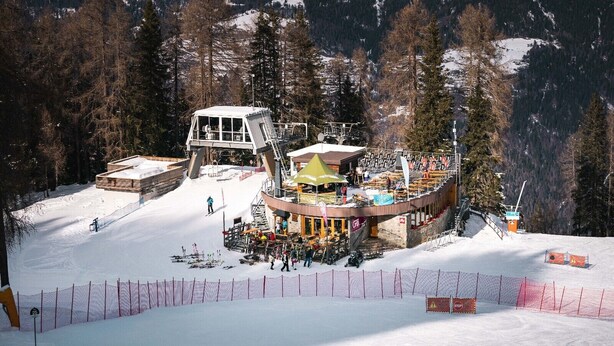 A ski resort with a lift station, a covered seating area, and a building with a sloped roof. - Apartment 'Marilleva 900 Kristall' with Mountain View, Shared Terrace and Wi-Fi (Mezzana)