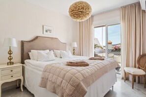 A bedroom with a large bed, bedside lamps, a chair, and a view of the outside. - Holiday Home 'Cecilia' with Sea View, Wi-Fi and Air Conditioning (Nerja)