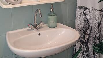 A bathroom with a sink, mirror, and shower curtain.
