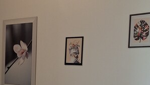 Une pièce avec un berceau, un radiateur et trois tableaux encadrés accrochés au mur.
