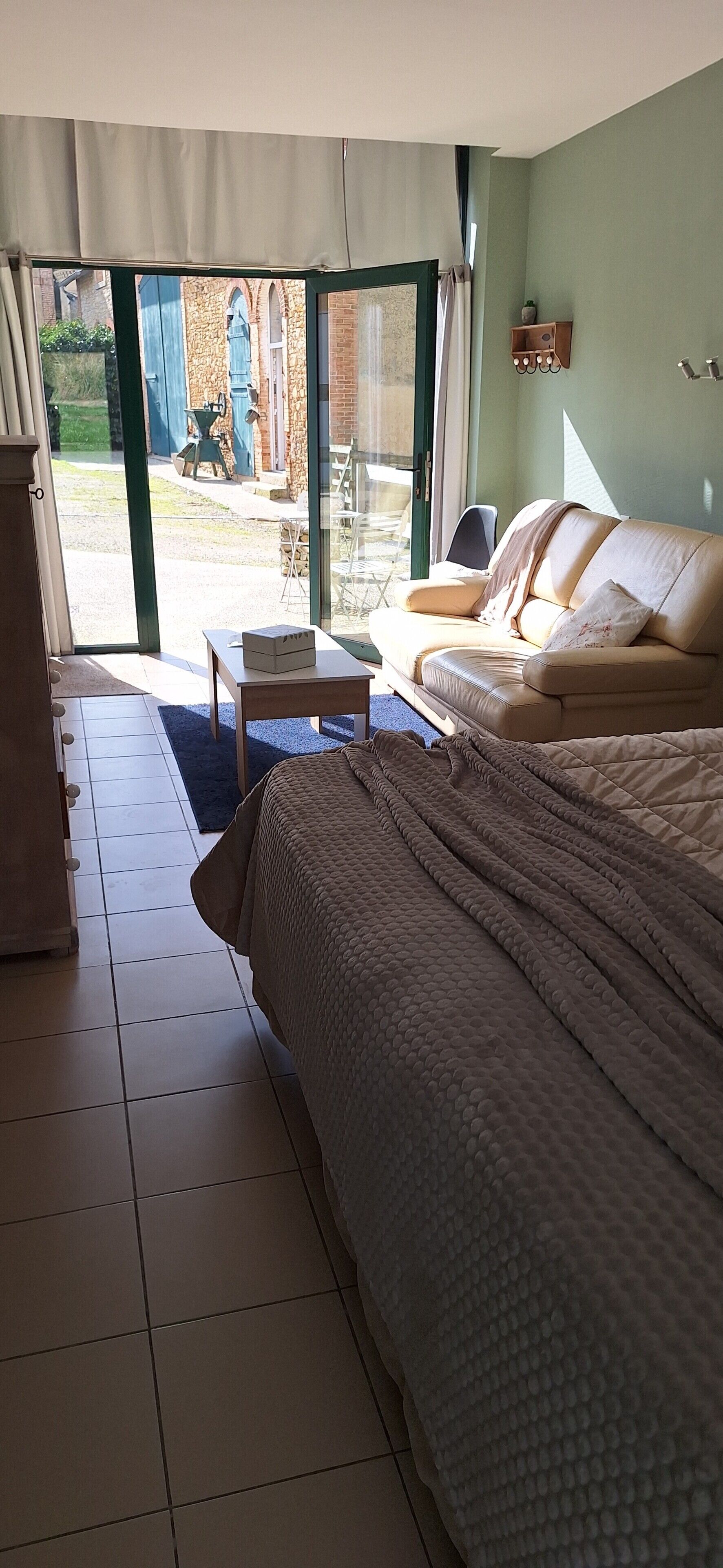Una stanza con un letto, un divano, un tavolino e vista all'esterno.