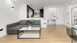 A modern living room with a grey sofa, a marble coffee table, and a small plant. - Apartment 'La Siesta 5' with Shared Pool, Wi-Fi and Air Conditioning (Fuengirola)