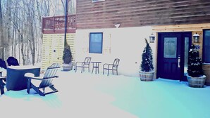 A wooden building with a balcony, outdoor seating, and potted plants. - Bright New 1 bedroom Retreat (Candler)