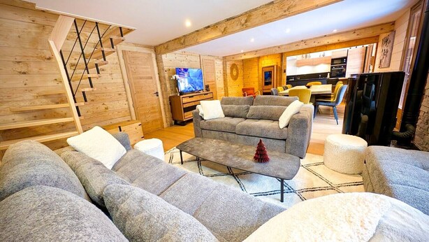 Un salon moderne avec un canapé, une table basse et un téléviseur.