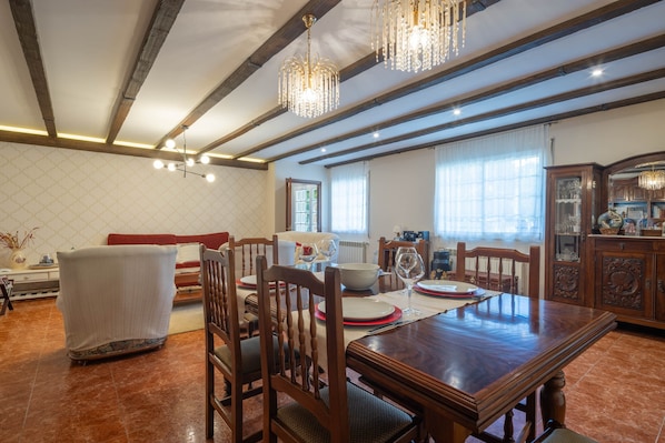 A dining area with a wooden table, chairs, and a chandelier.