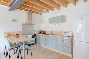 A modern kitchen with a wooden ceiling, a sink, a microwave, and a refrigerator. - Holiday Home 'La Ferme D'Alcide' with Private Terrace, Private Garden and Wi-Fi (Québriac)