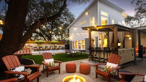 An outdoor patio area with Adirondack chairs, a fire pit, and a covered seating area with a table and chairs. - Heated Pool, MiniGolf, Karaoke, Game Room, Spa, 2mi to DT - SoCo Cowgirl (Austin)