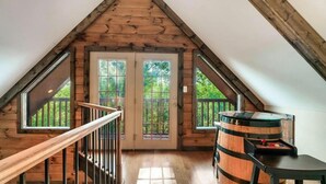 A wooden attic room with a staircase, large windows, and a barrel. - 10 mins to Dollywood, Stunning Views, Open Space & HotTub, Pet (Pigeon Forge)