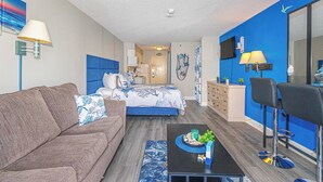 A bedroom with a bed, a sofa, a coffee table, and a TV. - Sea Mist 50504 (Myrtle Beach)