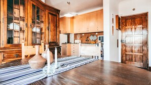 A dining area with a wooden table, a striped table runner, and a cabinet with glass doors. - Amadora Terrace View By Gt House (Amadora)