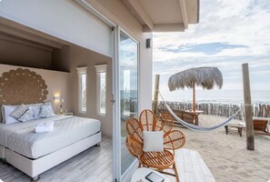 A bedroom with a large bed, a glass door leading to a balcony, and a view of the beach. - A charming beachfront bungalow overlooking the warm, calm sea. (Canoas)