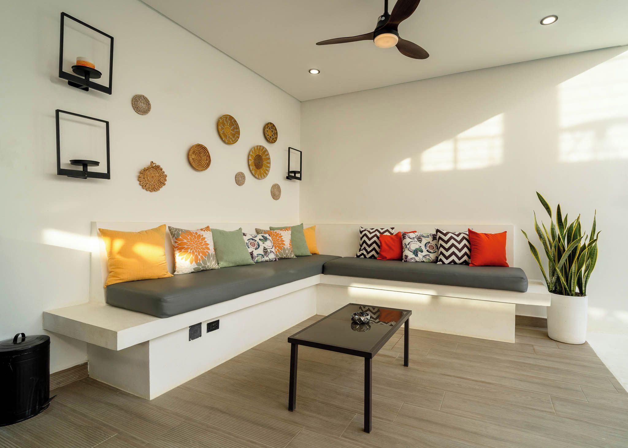 A modern living room with a sectional sofa, a coffee table, decorative wall art, and a potted plant.