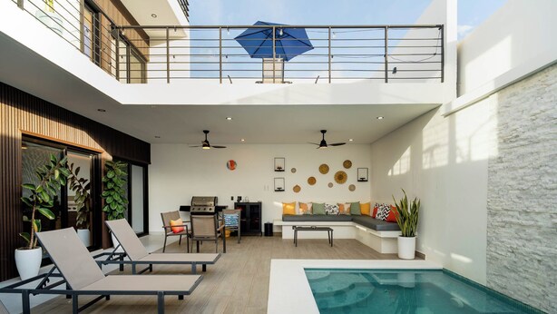 A modern outdoor living space with a pool, lounge chairs, a barbecue area, and a dining setup. - Ocean Dream Apartments E2-B4 (San Juan del Sur)