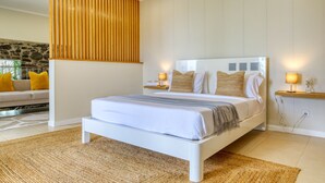 A modern bedroom with a white bed, wooden headboard, and two bedside lamps. - Ricardo House, a Home in Madeira (Calheta)