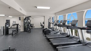 A gym with treadmills, elliptical machines, and weightlifting equipment.