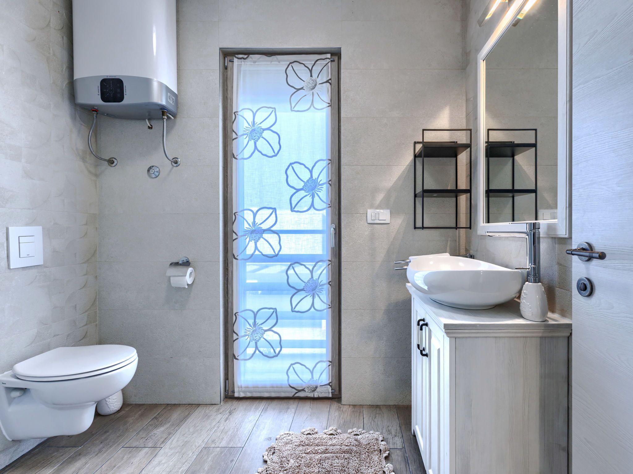 A modern bathroom with a toilet, sink, and shower.