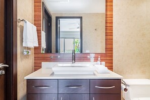 Un bagno con un ampio specchio, un lavandino bianco, un water e mobili in legno.