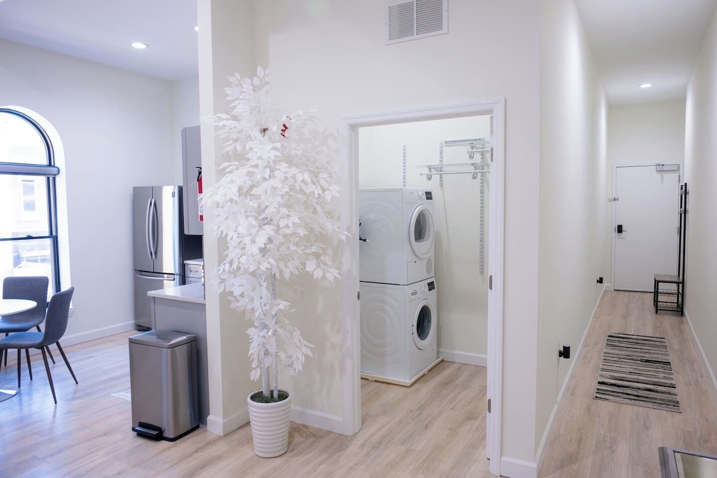 Een modern appartement met een eethoek, keuken, woonruimte en een wasruimte.
