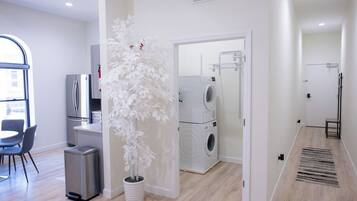 Een modern appartement met een eethoek, keuken, woonruimte en een wasruimte.