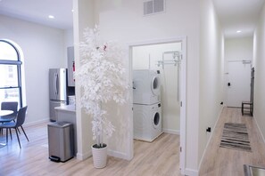 A modern apartment with a dining area, a kitchen, a living space, and a laundry room. - Royal Suite Modern Studio Downtown on the Square (Bloomington)