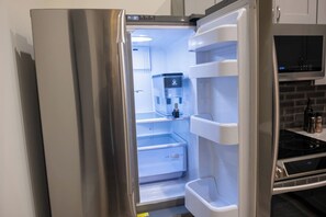 A stainless steel refrigerator with a digital display, a water dispenser, and a built-in ice maker.