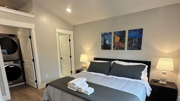 A neatly arranged bedroom with a bed, two bedside lamps, and artwork on the wall. - Modern 1BR Retreat • Near Sugar House & Downtown (Salt Lake City)